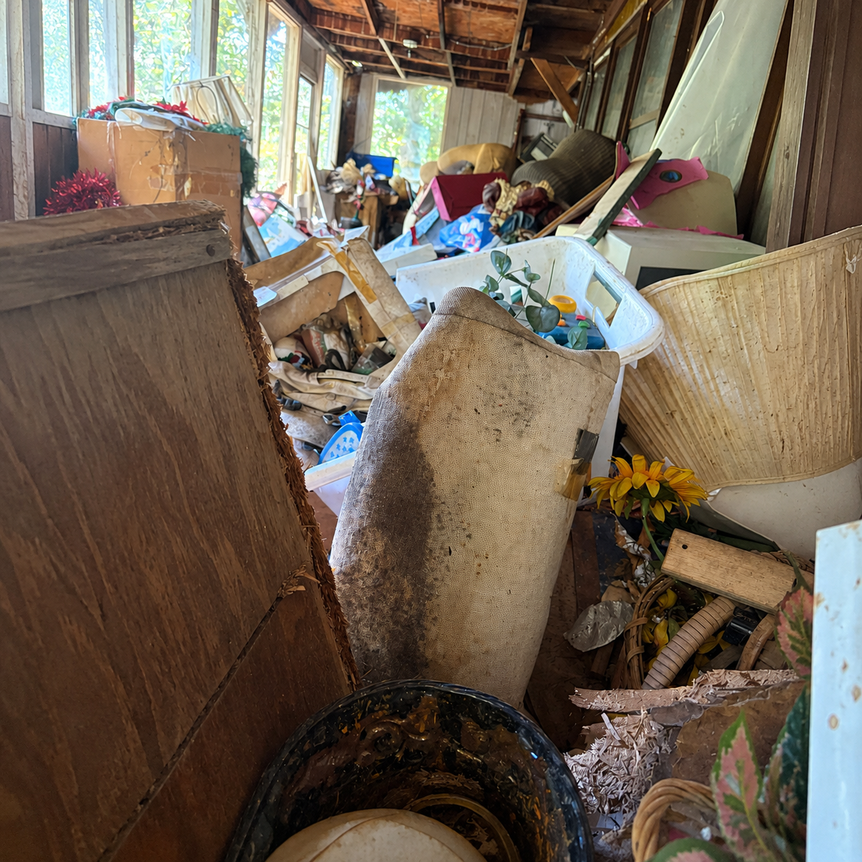 Cluttered screened porch before The Junk Unit NWA cleanout